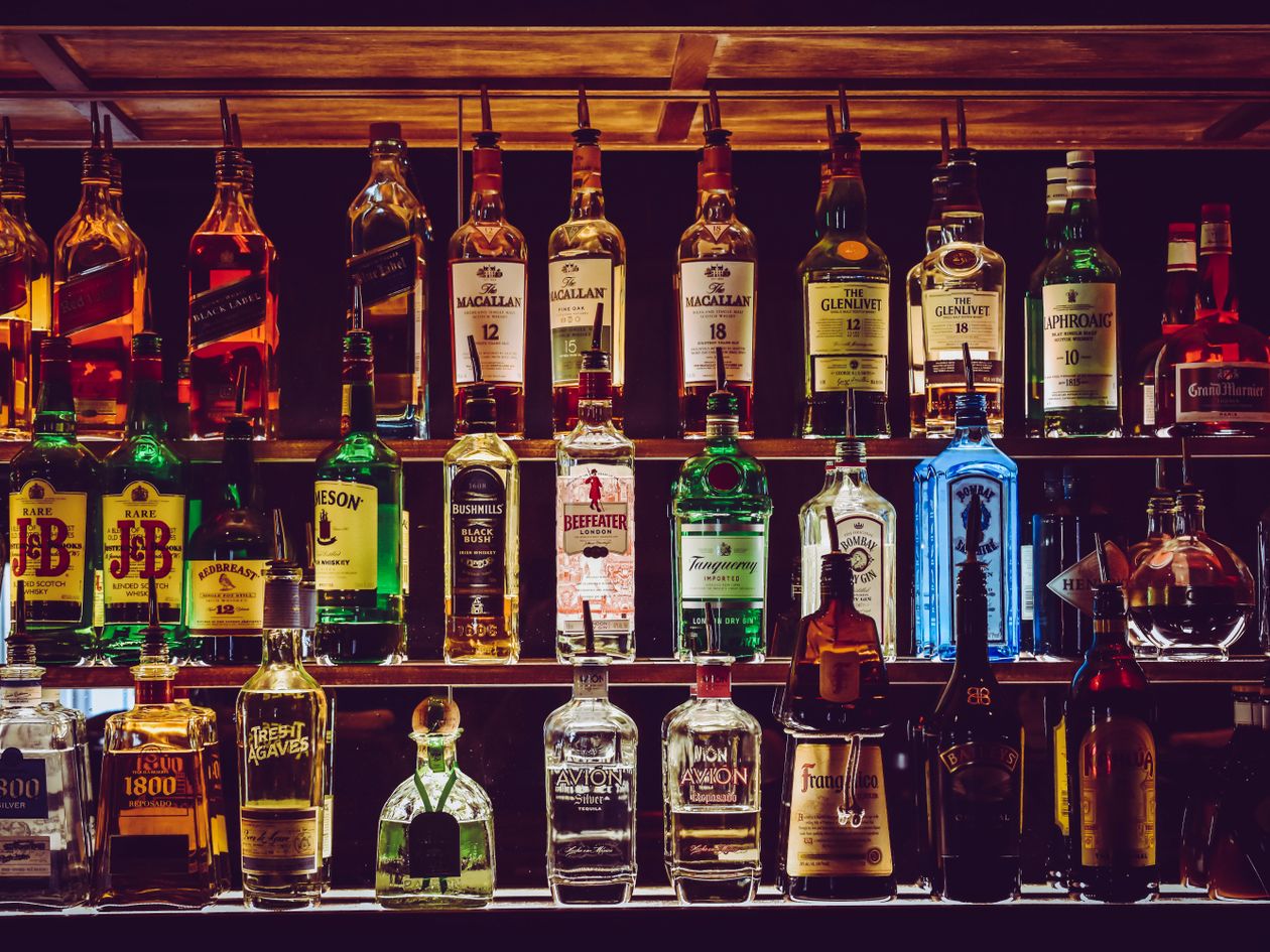 Assorted premium spirits on a bar shelf — brand and creative for beverage